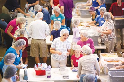 Volunteers spread throughout the worship center at Gayton Baptist church to package meals.